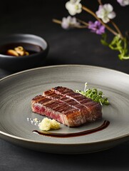 A premium black Wagyu steak, perfectly seared and plated with wasabi, sea salt, microgreens, and a delicate soy-based sauce drizzle.