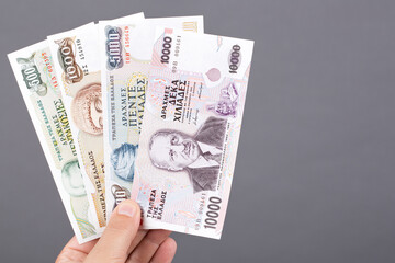 Greek money in the hand on a gray background