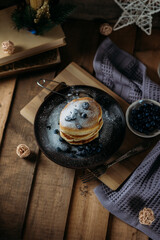 pancakes with blueberries and powdered sugar on a wooden background, breakfast, berries, vegan, dark background, healthy breakfast, pancakes with berries on fruit