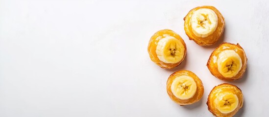 Delicious golden banana puffs arranged on a white background perfect for dessert advertisements or culinary presentations.