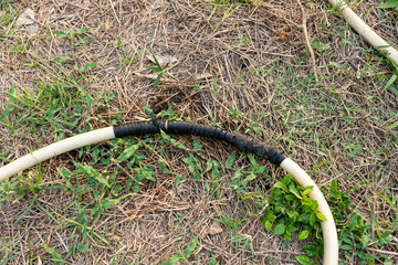 An old hose that leaks and is fixed by wrapping it with a rubber band.