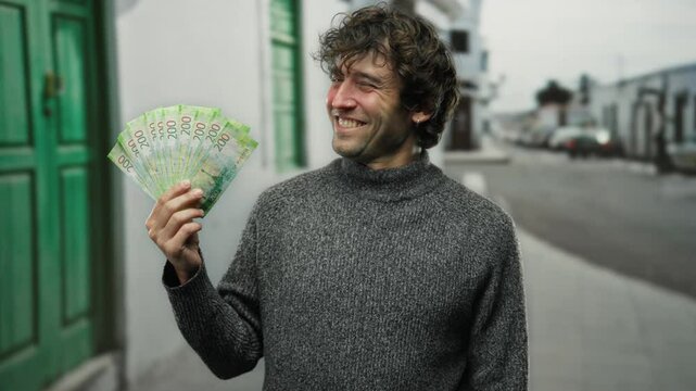 Man smiling holding russian rouble banknotes outdoors on an urban city street capturing a moment of financial success and happiness in a public setting.