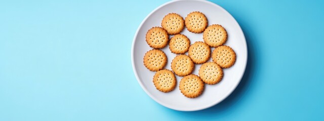 Digestive biscuits arranged on a white plate against a vibrant blue background ideal for healthy eating lifestyle ads and copy space needs