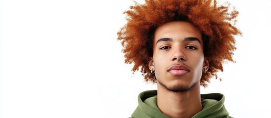 Charismatic young man with vibrant orange afro and nose stud wearing green hoodie isolated on white background with empty space for text.