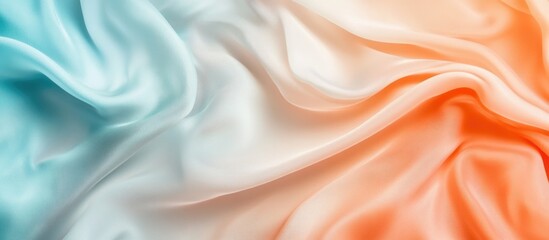 Obraz premium Elegant silk fabric folds in soft turquoise and coral hues with empty space for text or design elements.