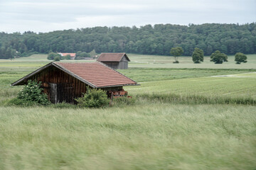 Large wooden barn for a farmer in a green field.