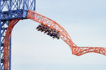 A roller coaster ride with people sitting upside down on the swing.