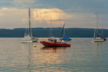 Sailboats and boats on the water against the backdrop of a gloomy evening sky.
