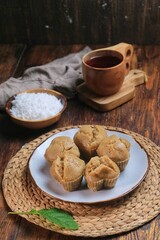 Kue Apam Gula Merah or Kue Apem or Kue Mangkok, Indonesian traditional steamed cake made from brown sugar served with grated coconut on a plate.
