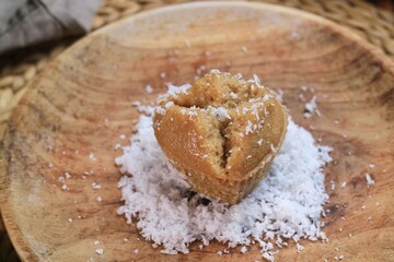 Kue Apam Gula Merah or Kue Apem or Kue Mangkok, Indonesian traditional steamed cake made from brown sugar served with grated coconut on a plate.
