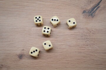 Scattered dice on wooden surface showing random numbers