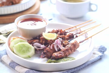 sate ayam or chicken satay, famous traditional Indonesian food, chicken meat on bamboo sticks and grilled, served on a plate