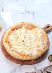 Homemade cheese tuna melt pizza with sweet corn on woodden tray. Selective focus
