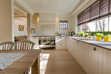 A modern kitchen with a spacious dining area and large windows overlooking a garden.
