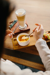 Close-Up of a Latte and Crème Brûlée Dessert on a Wooden Table