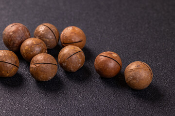 Macadamia nuts displayed on a dark background, ready for snacking
