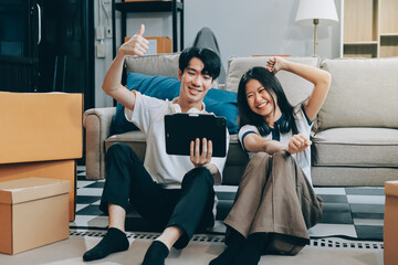 Fototapeta premium Smiling couple unpacking boxes in new house