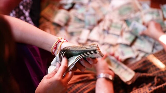 A young girl's hands counting Burmese money. 1000 Kyat, MMK.