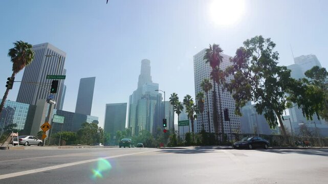 Daytime view of a street corner in Los Angeles with tall buildings and palm trees in 4K