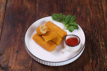 vegetables risoles or risol sayur or risoles sayur stuffed with veggies and enclosed in crepe-like wrappers and rolled into bread crumbs and fried. served on white plate and chili. selected focus
