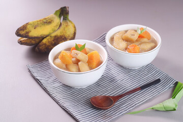 Kolak pisang is Indonesian traditional dessert made of banan and sweet potato with palm sugar sauce. Selective focus
