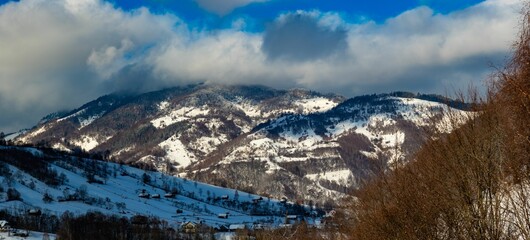 Snowy mountain landscape with dramatic clouds
