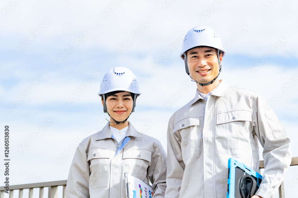 Poster エンジニア、作業員、建設、工事、安全、男性、女性、日本人、屋上、ビルメン、青空、管理、メンテナンス、点検、修理、工場、物流、ヘルメット、検査、作業服、人材、アルバイト、チームワーク、同僚、タブレット、IIoT、DX、笑顔、元気、やる気、仕事、職業、産業、製造業、工業、働く、建築、設計、技術者、電力、技師、解体、ゼネコン、工務店、土木、エネルギー、カメラ目線、二人、爽やか、人物