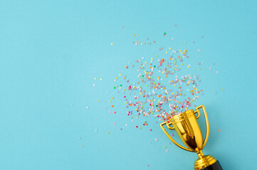 Bright sparkling background with winner cup. Flat lay, space for text.
