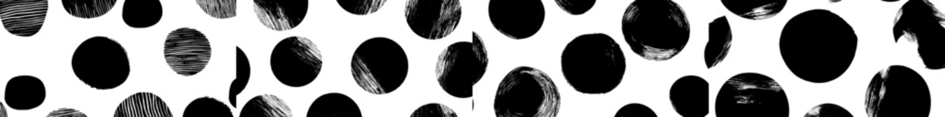A seamless pattern in black and white featuring rings created using a brush stroke technique forms an abstract background with hand-painted circular elements