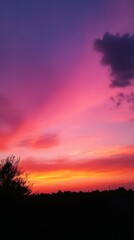 Fototapeta premium Vibrant Sunset Over Horizon with Colorful Sky and Silhouetted Landscape