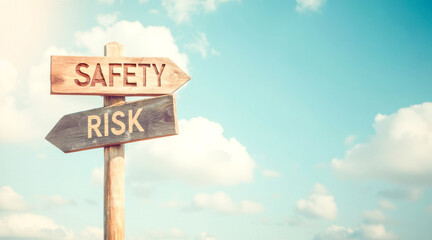 wooden signposts with carved words safety and risk against a blue sky