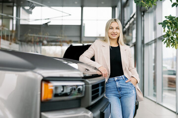 Business woman leaning on new pickup truck in car dealership showroom © nazariykarkhut