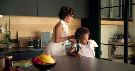 Mom, child and getting ready with school bag in kitchen for learning journey or morning at home. Happy mother, kid or helping little boy with backpack for academic preparation or education at house