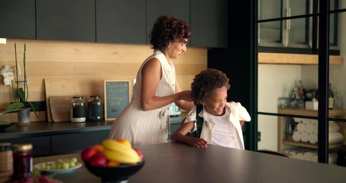 Mom, child and getting ready with school bag in kitchen for learning journey or morning at home. Happy mother, kid or helping little boy with backpack for academic preparation or education at house