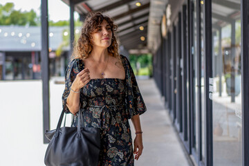 Fashion-forward woman admiring stylish displays in a vibrant shopping area