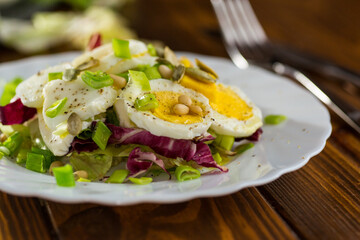 Appetizing egg dish in a plate on a wooden table