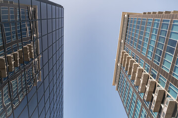 Blue skies between Skyscrapers. Urban landscape with high-rise buildings. View from bottom to top.