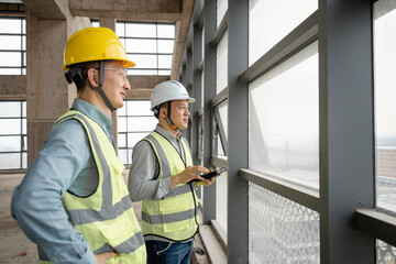 two asian male engineer working in construction site