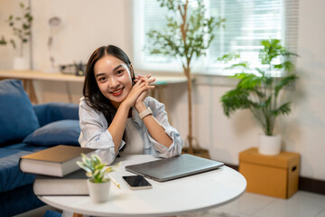 A woman is sitting at a table with a laptop and a book