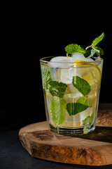 Mojito cocktail with ice and mint on a black background.