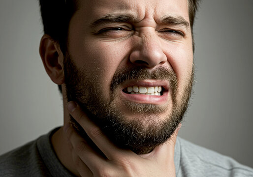 Man expressing discomfort with emotional distress and pain expression in gray shirt