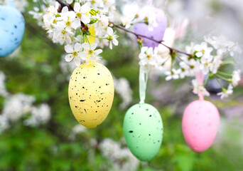 A woman's hand holds a decorative Easter egg. Easter spring composition. Selective focus.