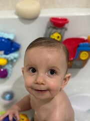 A baby boy playing in the bath