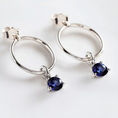 Elegant silver hoop earrings with sapphire gemstones reflecting beauty and sophistication