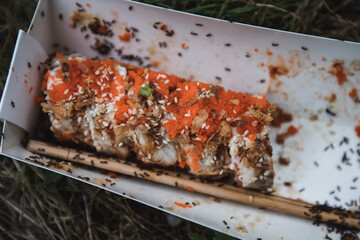 Spoiled sushi are lying on the ground. Insects in the sushi. Sushi were thrown away. Not tasty. Throw away food.