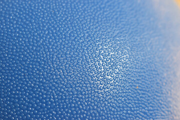 Close up of textured blue surface with bumpy pattern and soft lighting open copyspace