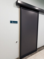 Vertical photography of slider entry door in handicapped restroom