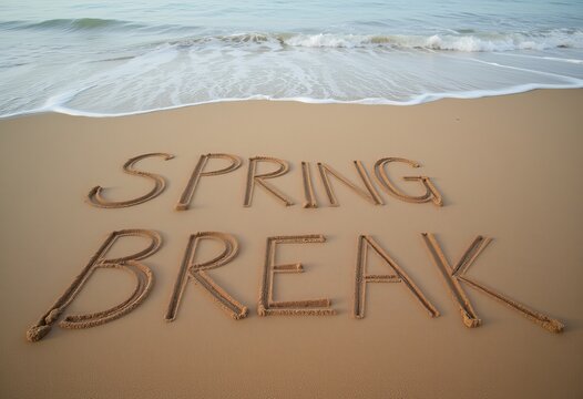 Spring break message written in sand by ocean waves with clear blue sky background perfect for vacation themes