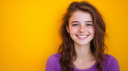 Fototapeta premium Cheerful teen girl smiling against bright yellow background