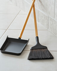 Broom and dustpan set with wooden handles on tiled floor